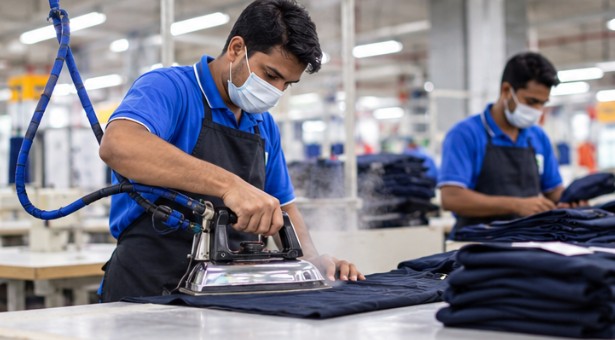 Pressing a finished garment on a partner factory floor